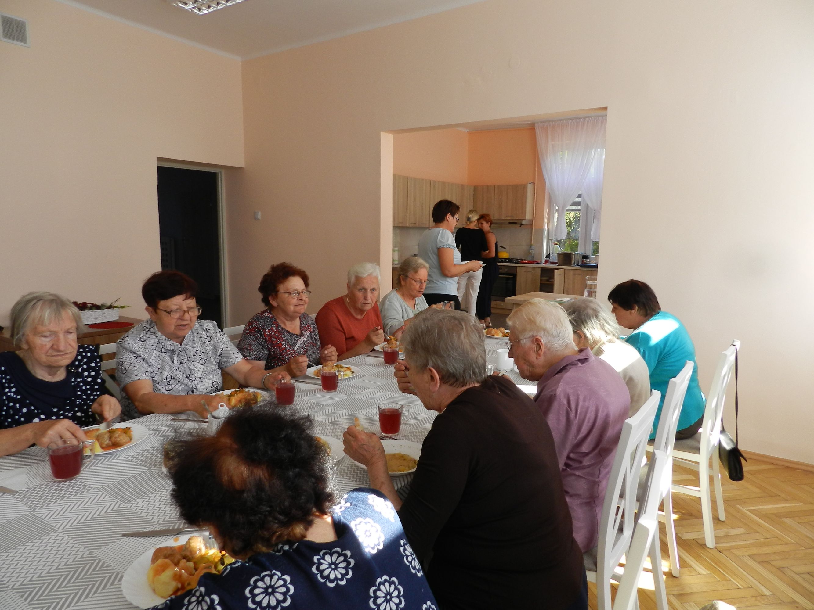 Uczestnicy Dziennego Domu Pomocy podczas obiadu w godzinach pracy Domu, 10 osób przy stole