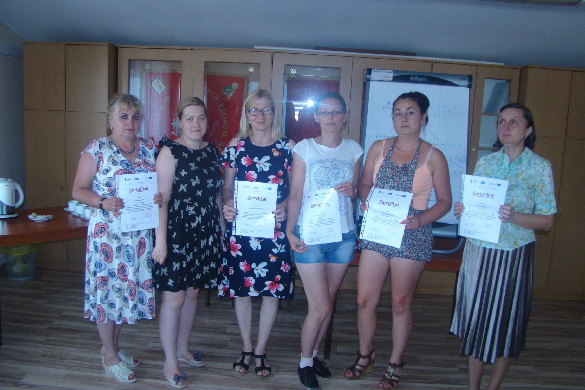 Uczestnicy szkolenia 5 osób razem z pania psycholog stoją w rękach trzymają dyplomy